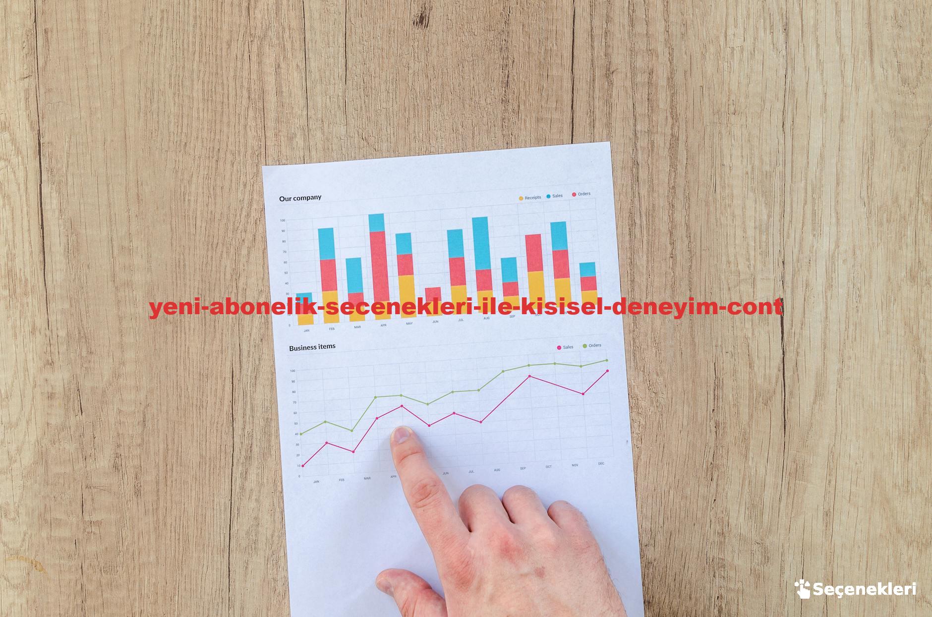 A hand points to colorful business charts and graphs on a paper sheet on a wooden desk.